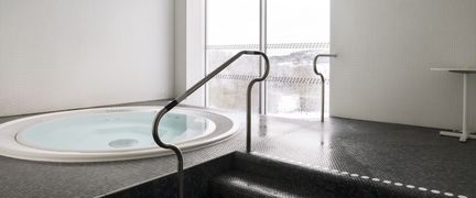 En bubbelpool med ett fönster i bakgrunden. Genom fönstret syns träd och fält.