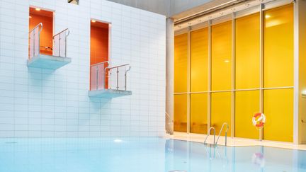 Bassäng med avsatser för hopp i bakgrunden.