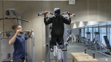 Ung person tränar på gym med instruktör.