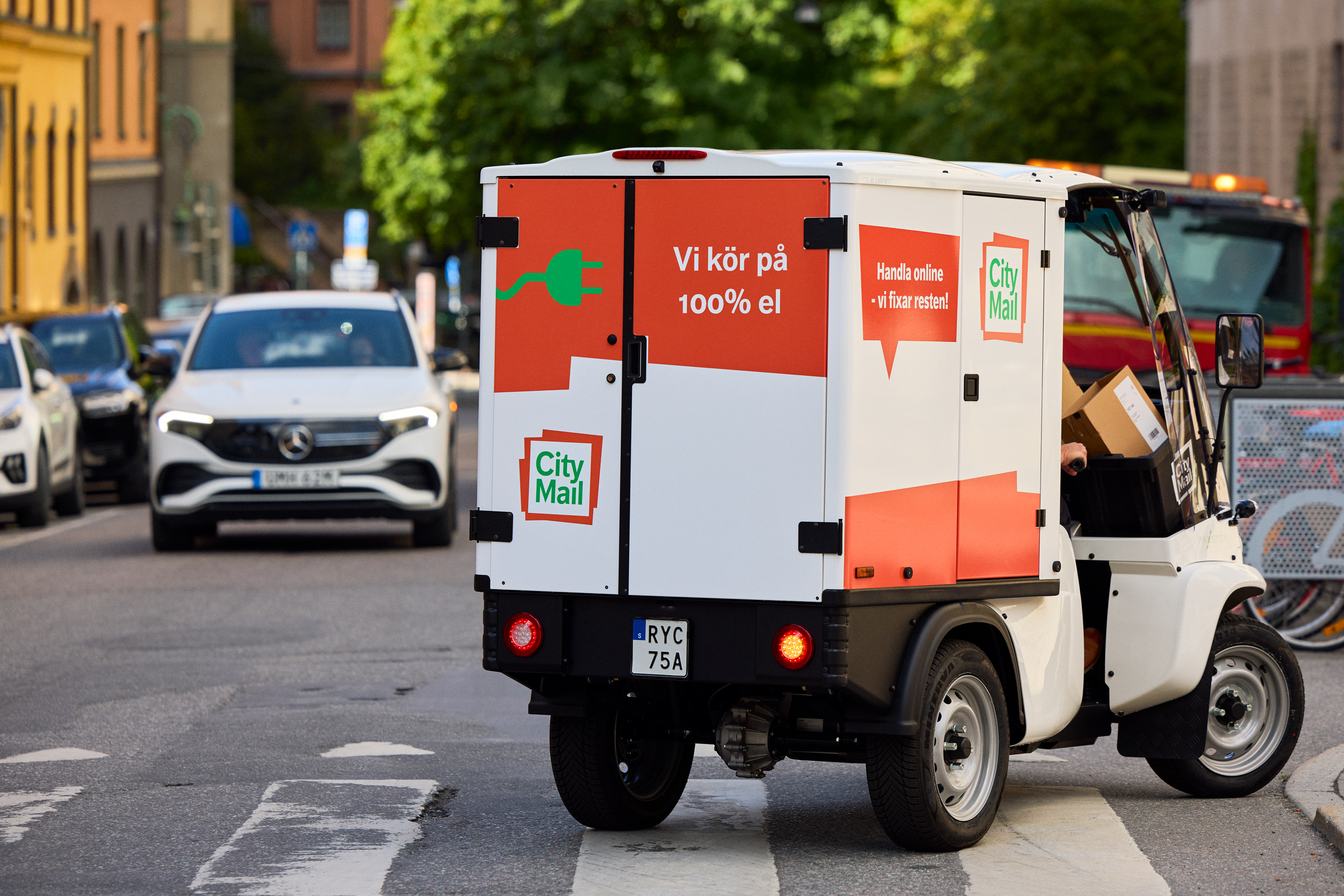 En mindre budbil i stadsmilj&ouml; med texten "Vi k&ouml;r p&aring; 100% el"