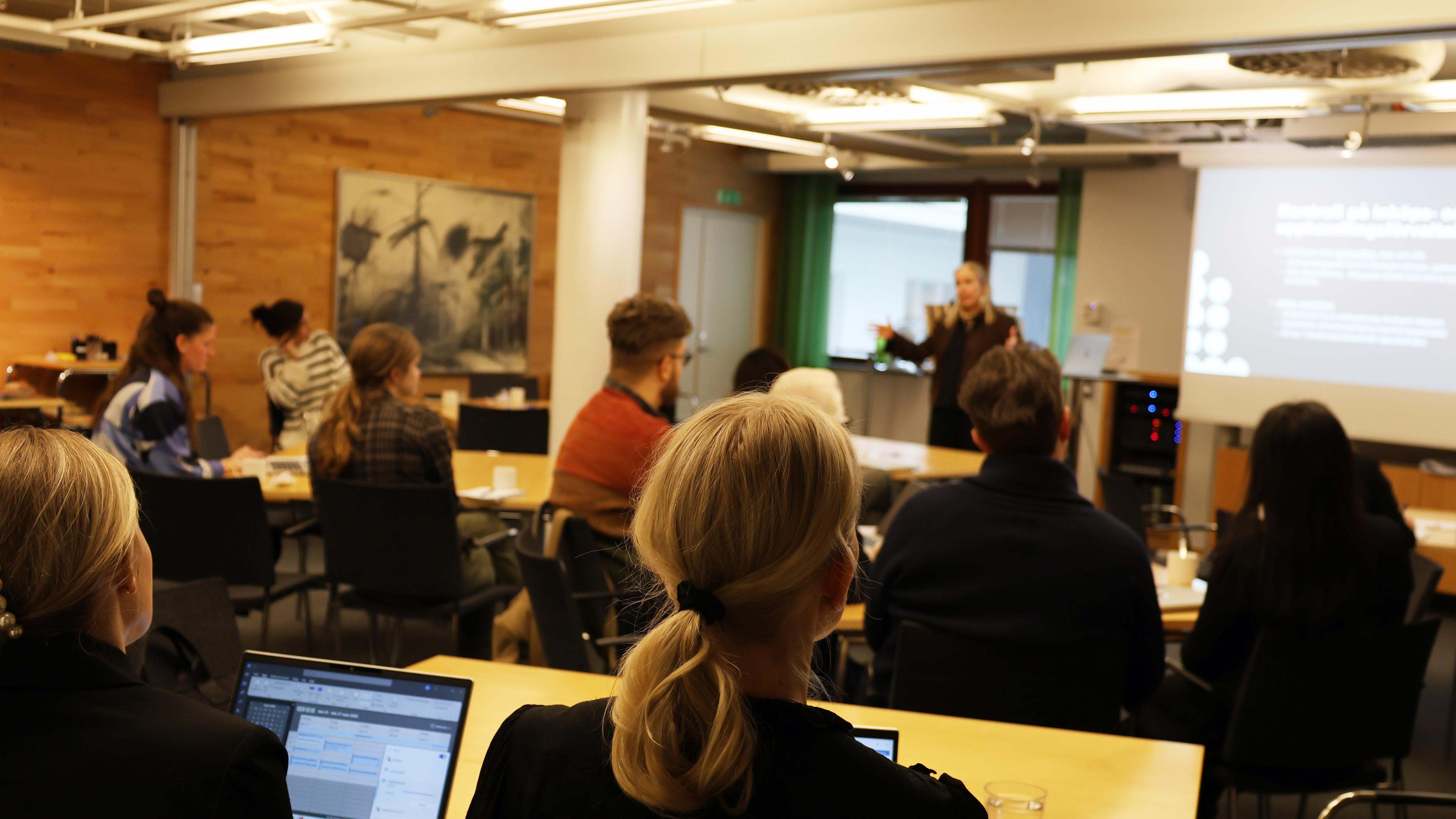 En grupp p&aring; ca 40 personer lyssnar p&aring; en f&ouml;rel&auml;sare i ett konferensrum