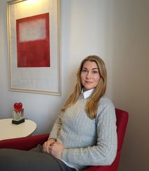 Lina sitter i en fåtölj och tittar in i kameran.