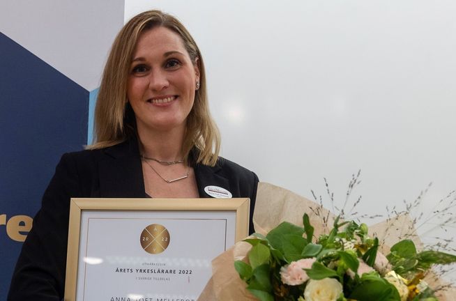 Anna med blombukett och inramad utmärkelse för årets yrkeslärare 2022. 