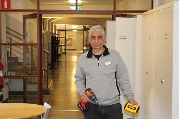 Nazif står redo med en borr i skolkorridoren.