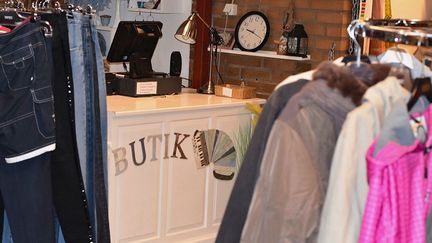 En kassadisk med texten butik och kläder runt omkring.