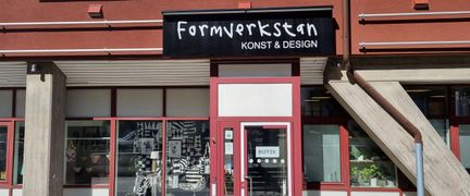 Stora skylfönster och en dörr med skylten Formverkstan ovanför. 