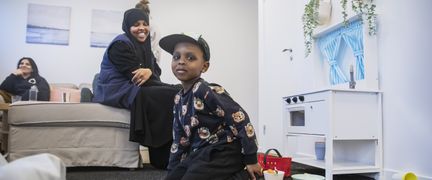 En kvinna som tittar på ett lekande barn.