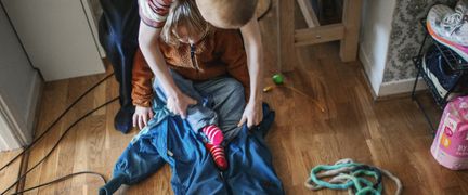 Ett barn som får hjälp med påklädning