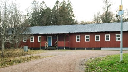 Ett långt rött enplanshus av trä