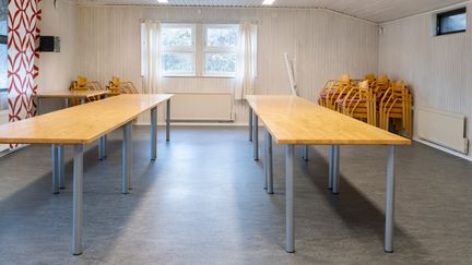 Möteslokal med ljusa väggar och två långa bord. 