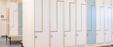 Omkädningsrum med vita och ljusblå låsbara skåp