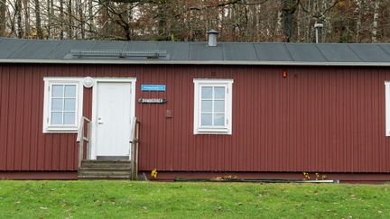 Litet rött trähus i ett plan