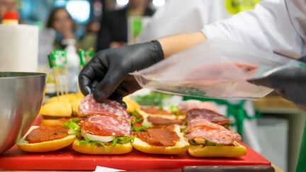 En person gör smörgåsar.