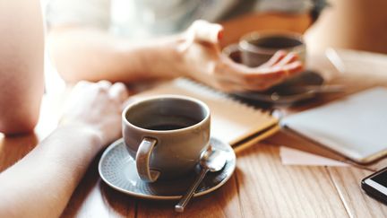 Två personer fikar med kaffe.