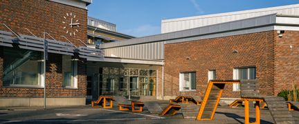 En skolgård i asfalt framför en skolbyggnad i tegel