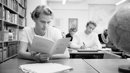 Elever som läser i ett klassrum. 