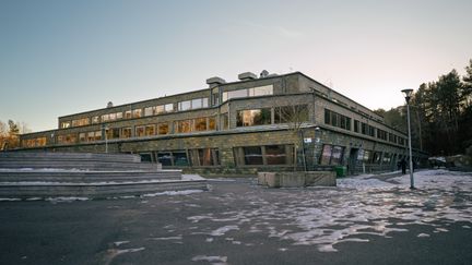 Svartedalsskolans skolgård med några bänkar och personer i bakgrunden.