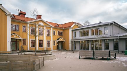 Backaskolans entré med några bänkar i bakgrunden.