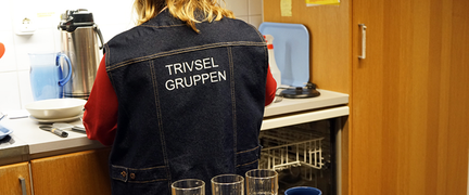 En person står i ett kök och tar hand om disk.