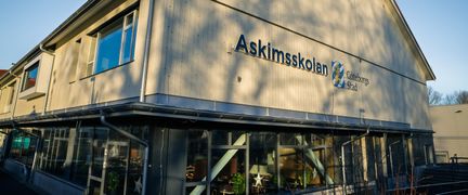 Askimsskolans huvudbyggnad med skolans skylt i fokus.