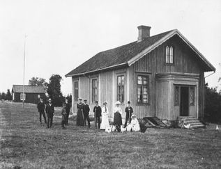 Askimsskolans gamla skolbyggnad med några personer i fokus.