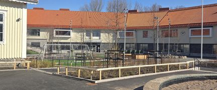 Askimsskolans skolgård med några gungor och en sandlåda i bakgrunden.
