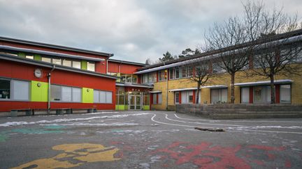 Ellen Keyskolans entré och skolgård med några bänkar och träd i bakgrunden.