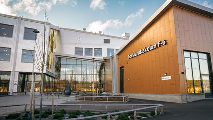 En skolbyggnad med texten Torslandaskolan F-6 på fasaden och en glasad entré