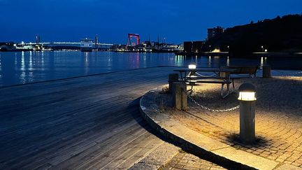 Norra älvstranden i förgrunden, med älven och Hisingsbron i bakgrunden, på natten.