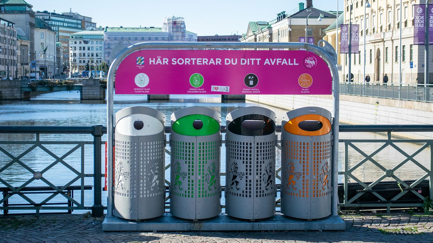 Fyra avfallskärl i olika färger för sortering av avfall