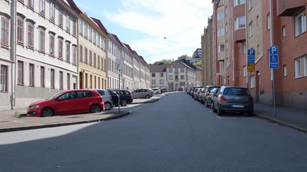 Kaptensgatan i Majorna med fickparkeringar på höger sida och sidoparkeringar på vänster sida. Äldre höghus och trottoar på vardera sida om parkeringen.