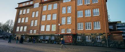 Lundenskolans huvudbyggnad med några personer i bakgrunden.