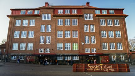 Lundenskolans huvudbyggnad med några personer i bakgrunden.