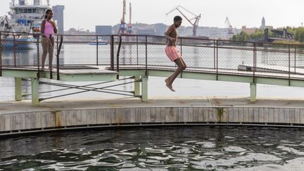 Pojke hoppar ner i bassängen. 