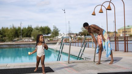 Flicka vid hamnbassängen och en vuxen i sällskap