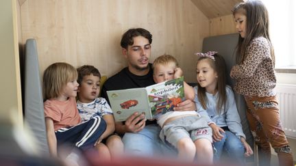 Elev som läser bok för barn. 