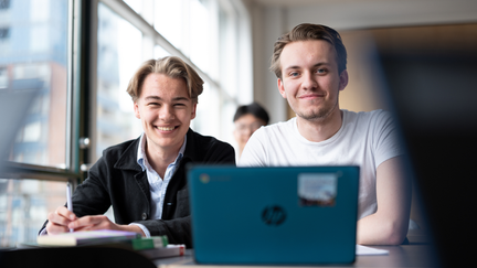 Två elever ler mot kameran