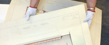 Händer håller i en ritning