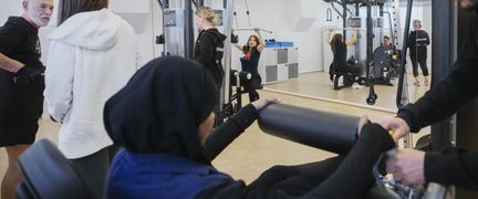 Foto av flera personer i ett gym.