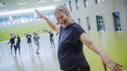 En glad kvinna leder ett danspass.