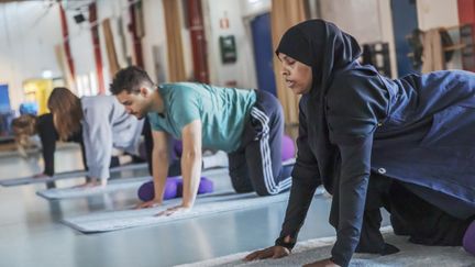 En grupp män och kvinnor i en idrottshall.