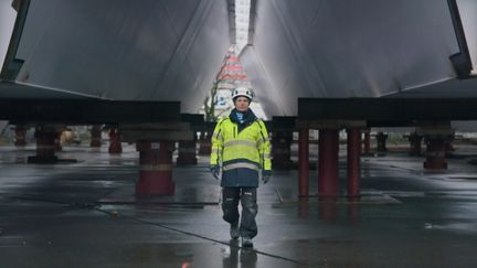 Man i byggnadsskyddskläder promenerar under Hisingsbrons byggnation.