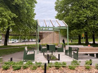 Pergola med tak, sittplatser och planteringar