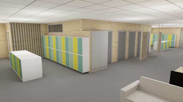 Skolkorridor med väggar i plywoodträ. Elevernas skåp har olika nyanser av ljusgrön och gula färger.