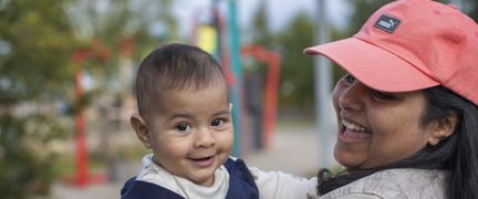 En kvinna som bär på ett spädbarn