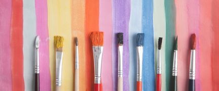 En bakgrund med olikfärgade streck och på varje streck ligger en pensel .