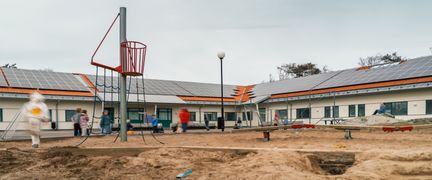 En lekplats utanför Donsöskolan. I bakgrunden kan några barn som spelar fotboll ses.