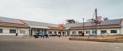 Donsöskolans skolgård med några barn som spelar fotboll. I bakgrunden kan en lekplats ses.