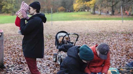 Ett foto av en förälder som är ute med sina tre barn i parken.