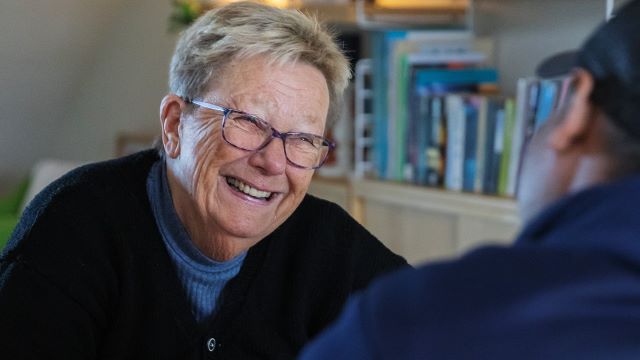 Person med glasögon som ler.